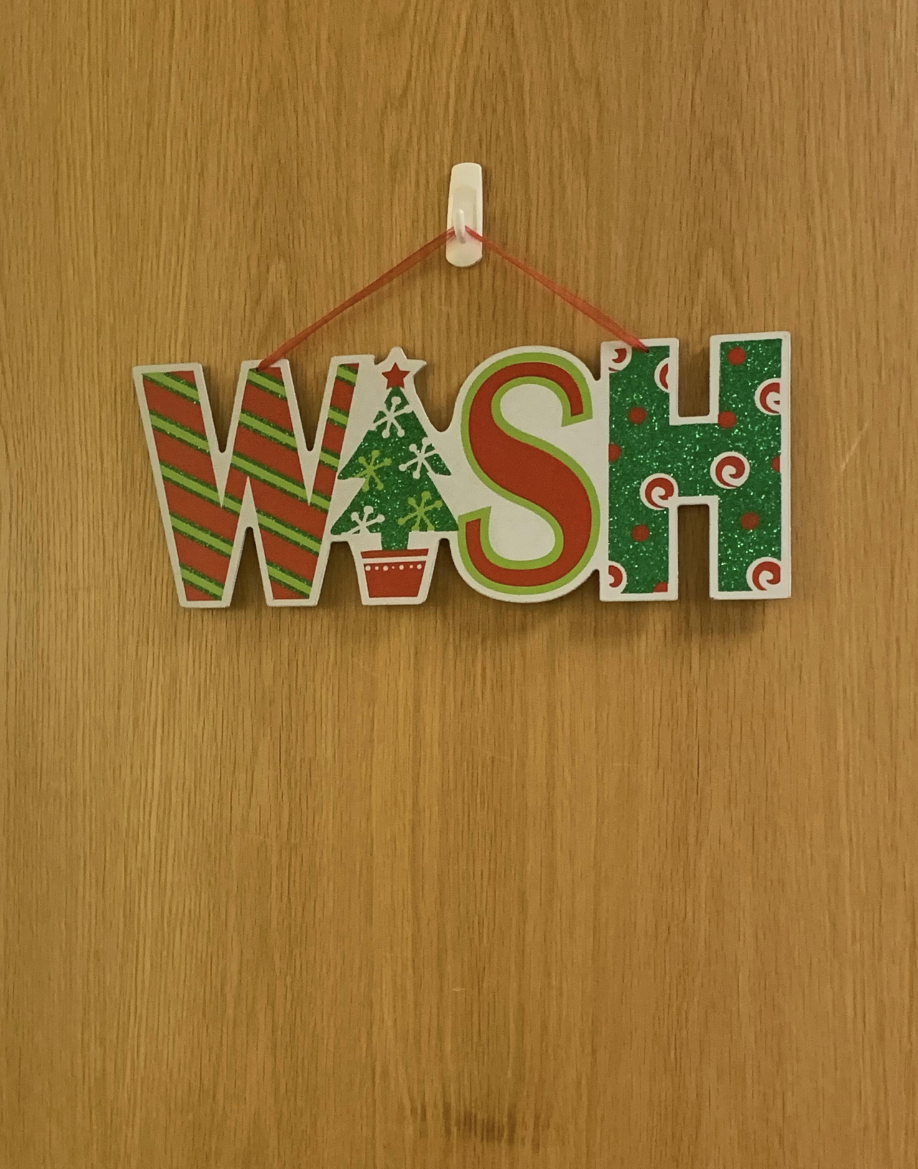 A &quot;wish&quot; sign hanging on a wall, with a Xmas tree where &quot;I&quot; should be