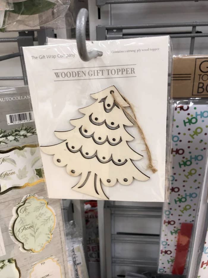 Wooden gift topper with what looks like rows of breasts on it
