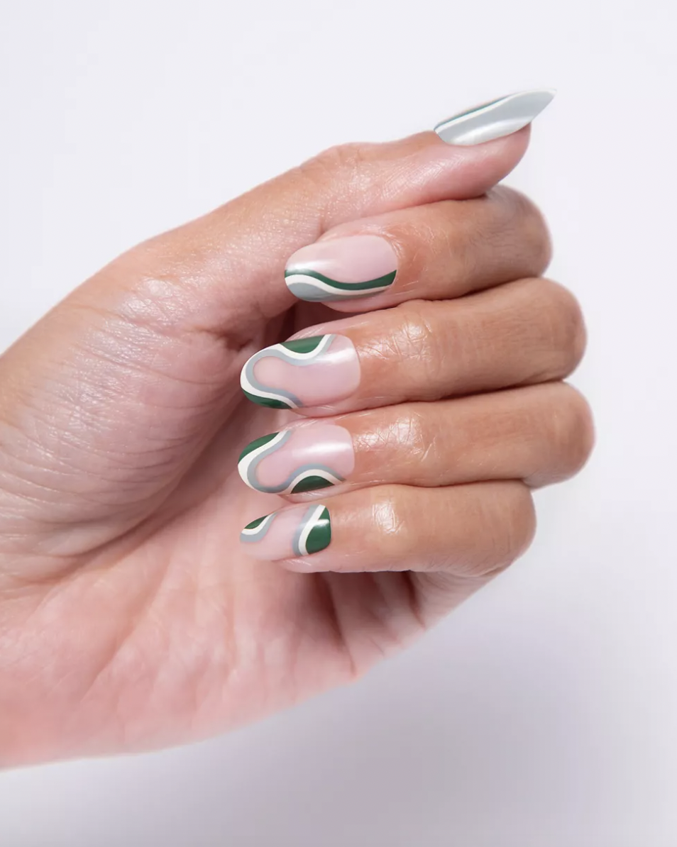 a close up of a person wearing a set of the press on nails