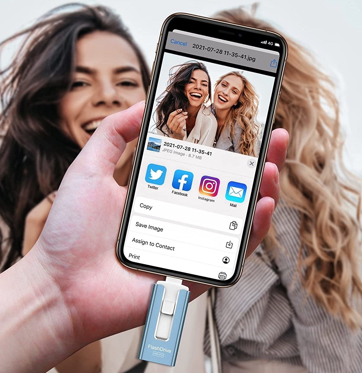 A person holding a phone with the flash drive in it