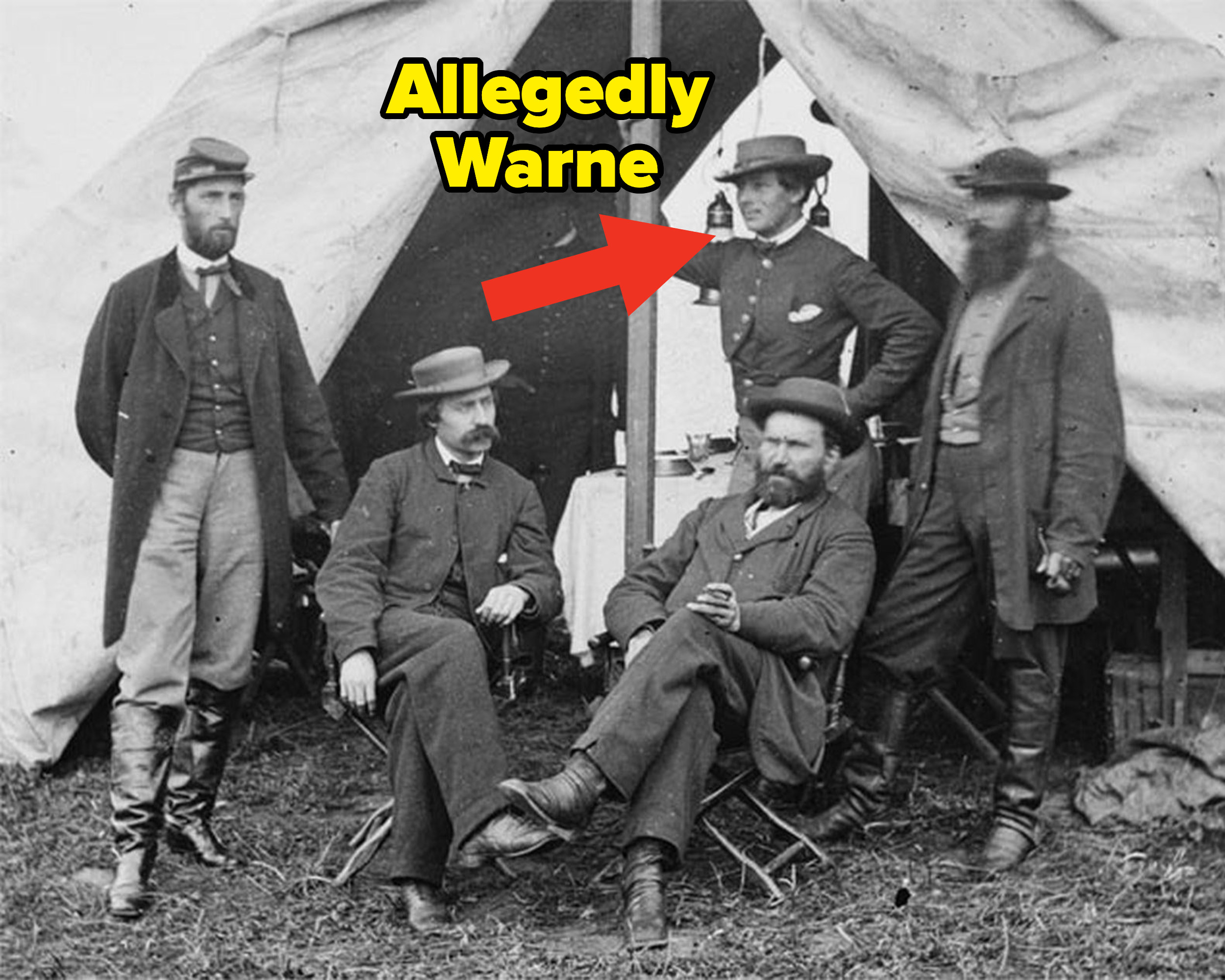 old photo of a group of mean outside a tent with an arrow pointing to one in the back that is allegedly warne in disguise