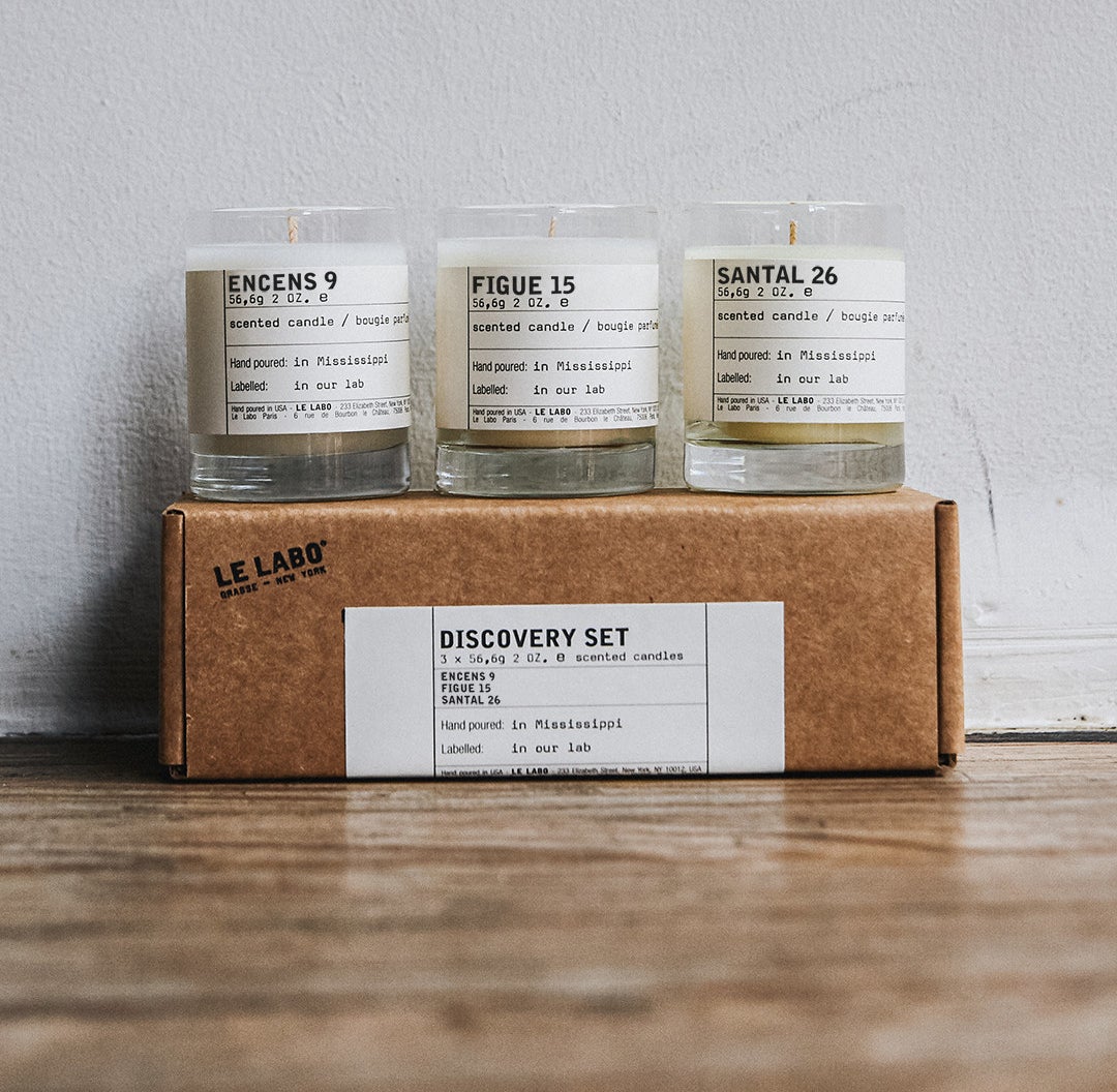 a trio of le labo mini candles on top of the gift box they come in