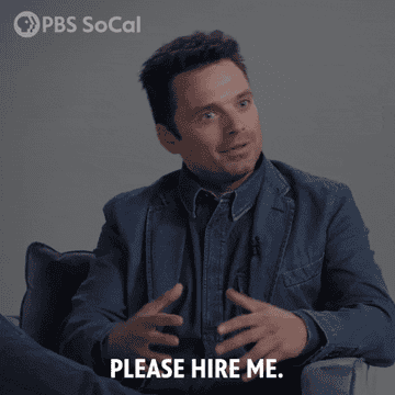 man sitting on a chair saying please hire me