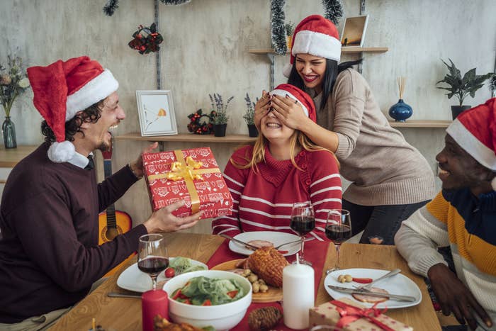 friends at a dinner table wearing Christmas hats