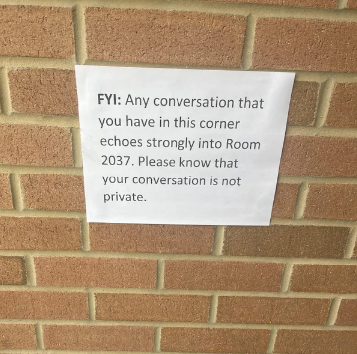 Sign says, Any conversation that you have in this corner echoes strongly into Room 2037. Please know that your conversation is not private.