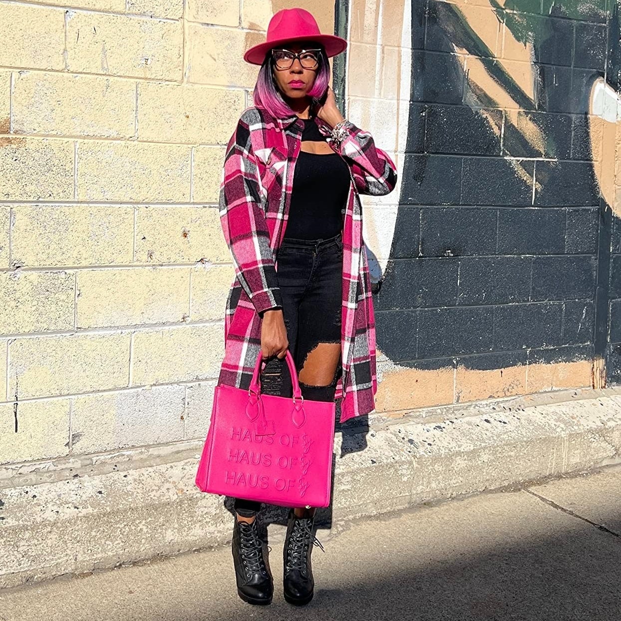 a reviewer wearing the pink and black flannel coat