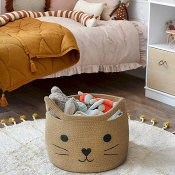 a brown cat basket with a bunch of toys inside