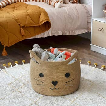 a brown cat basket with a bunch of toys inside