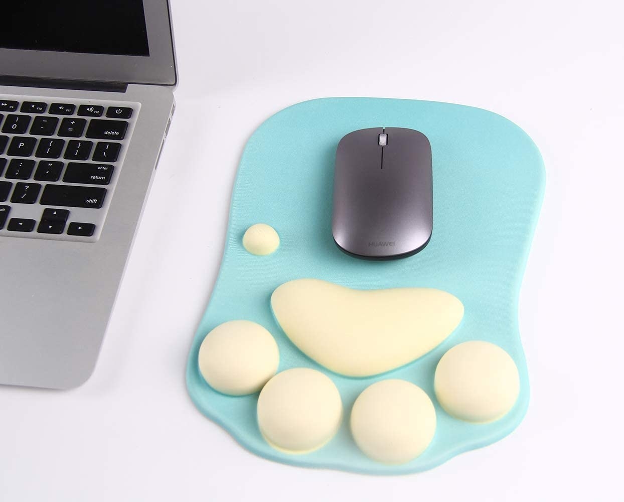 A green mouse pad with light yellow cushions in the shape of a cat paw for wrist support