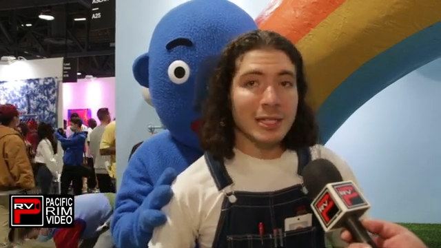 artist danny cole, creator of creature world nfts, speaks to camera with a real life creature behind him
