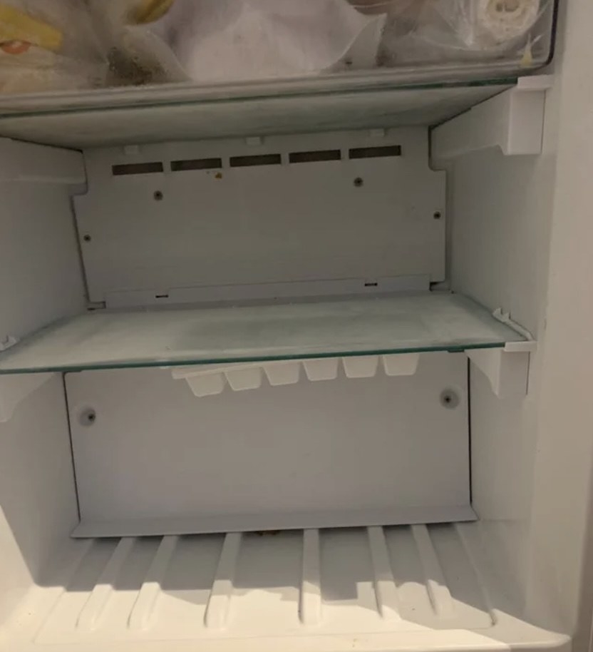 An ice tray stuck to a freezer shelf