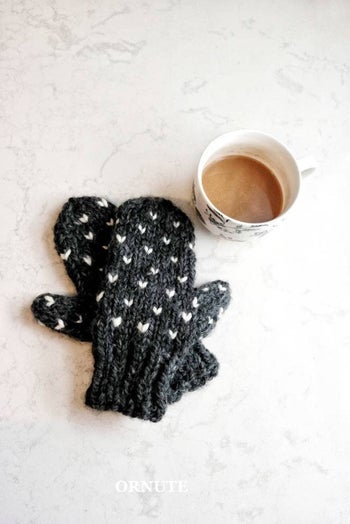 black mittens with tiny white hearts stitched onto them