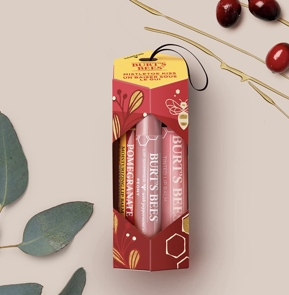the lip balms in a box beside cranberries and leaves