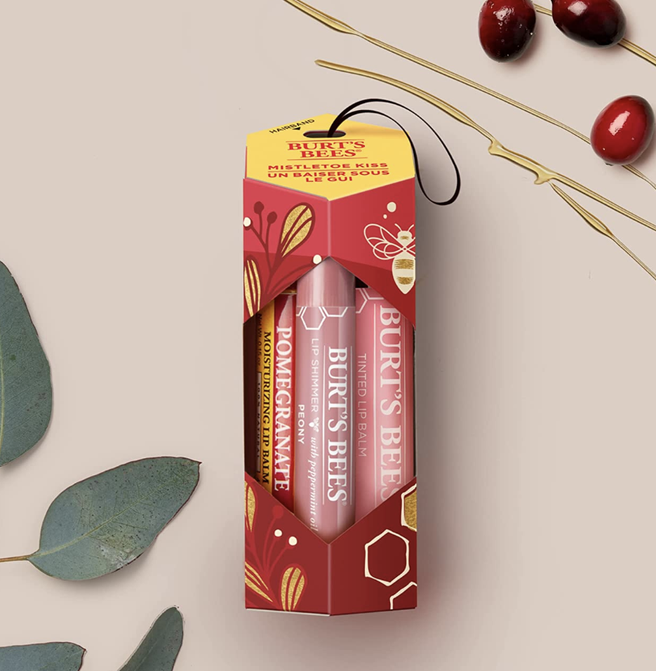 the lip balms in a box beside cranberries and leaves