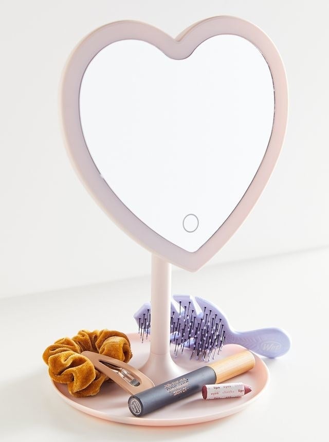 a heart shaped mirror with a tray as its base