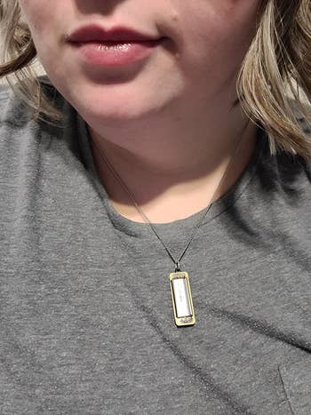 reviewer wearing the harmonica necklace