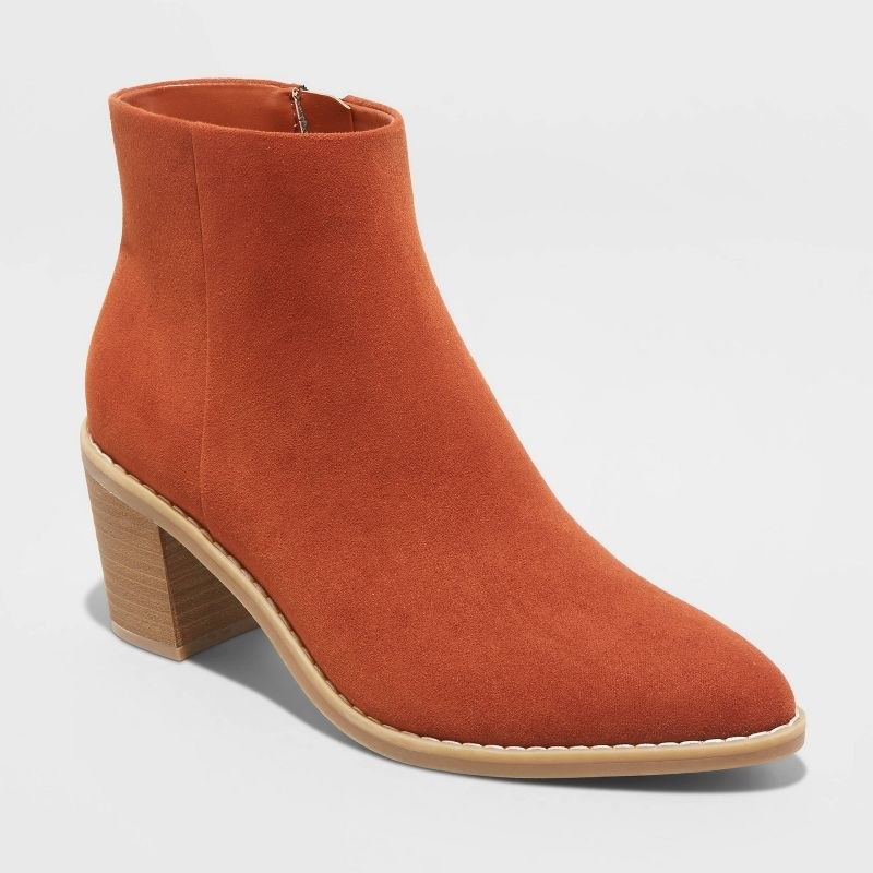 An orange pair of boots with a brown heel