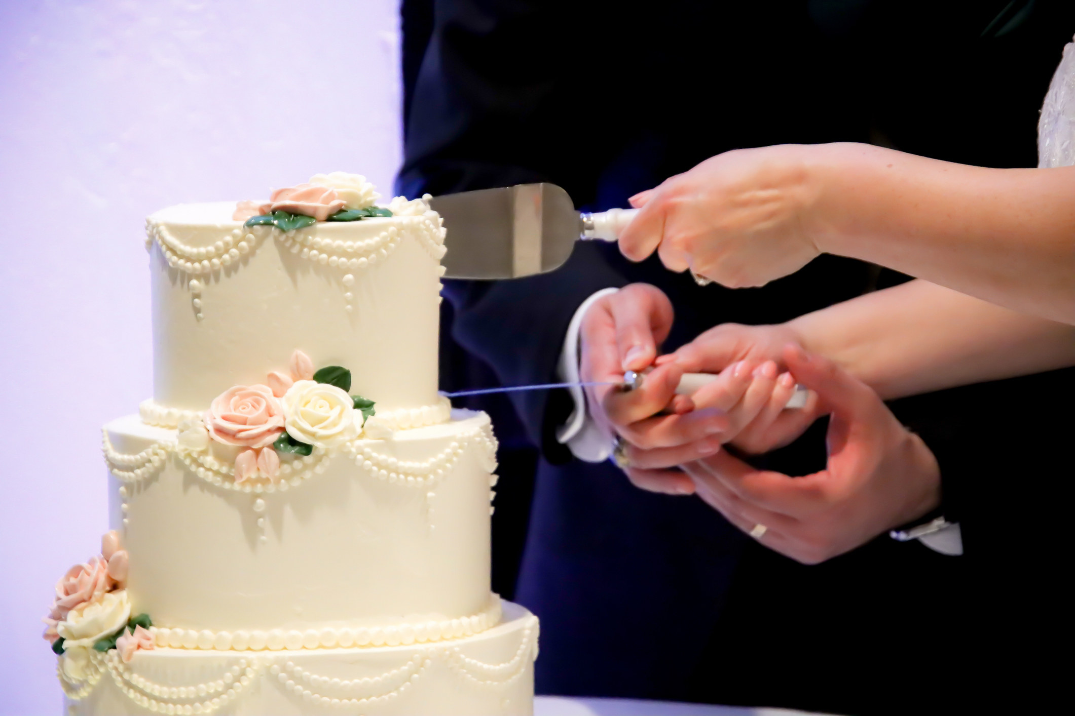 Bride and groom cutting a three-tiered cake