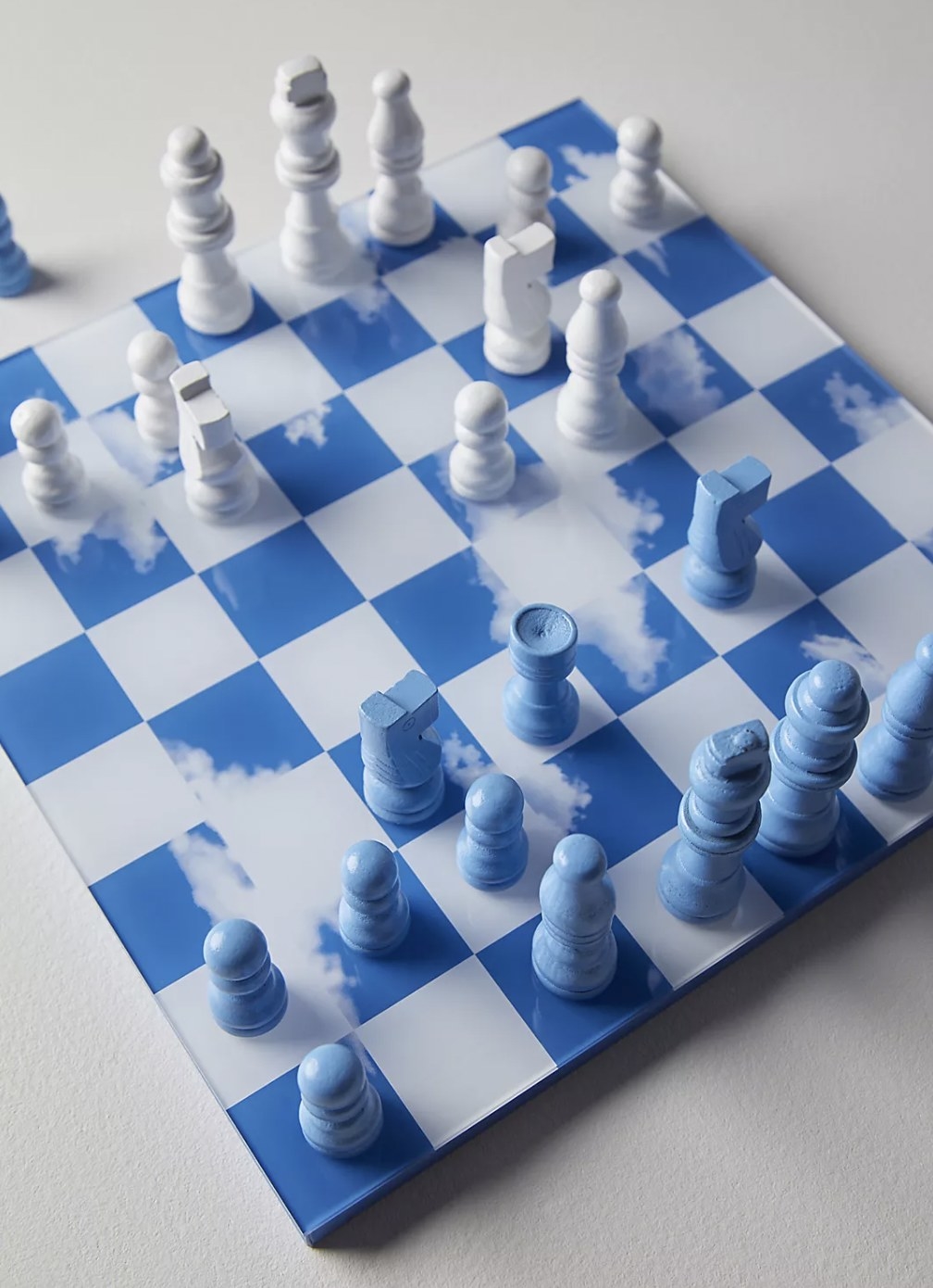 the chess board with cloud designs and blue and white pieces