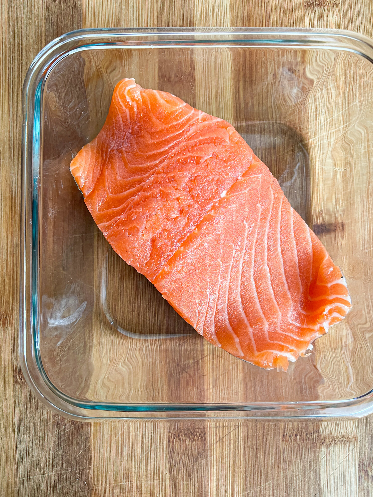 A piece of salmon on a glass platter