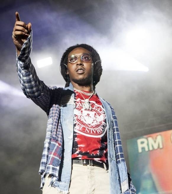 Takeoff pointing at the audience as he stands onstage