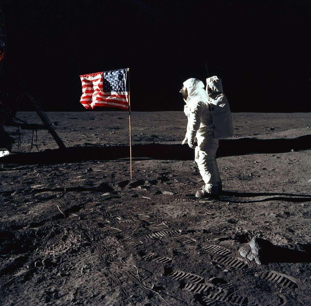 man on the moon with an american flag posted