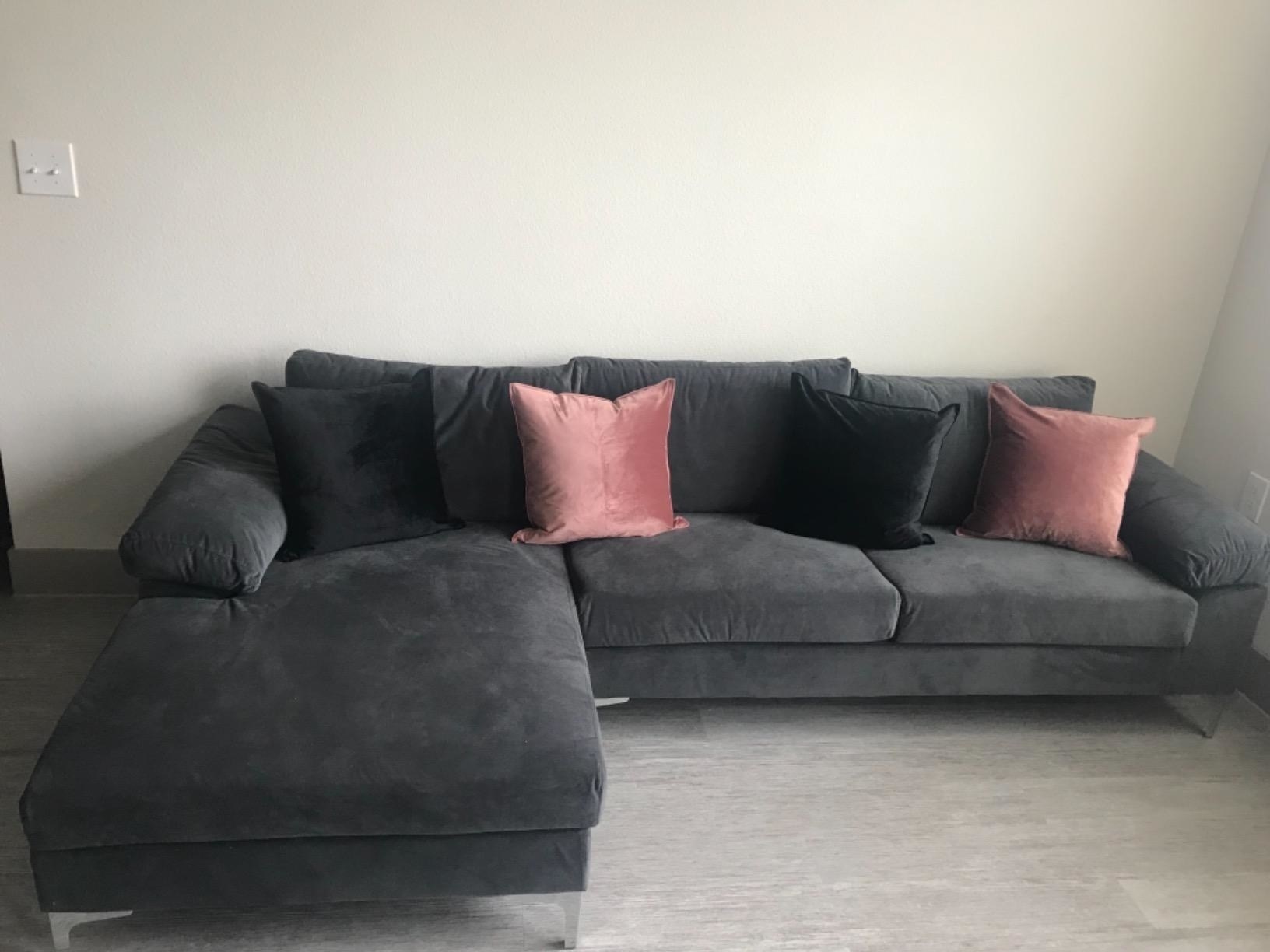 couch with four velvet throw pillows on it
