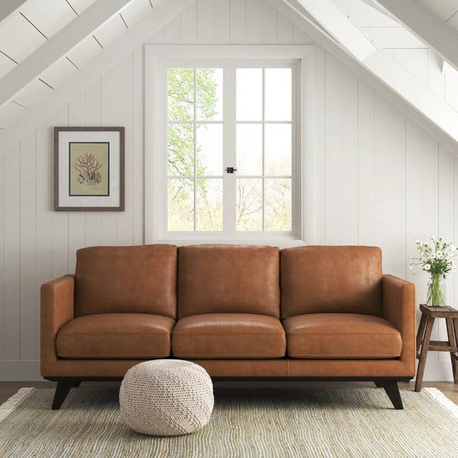 a camel-colored leather sofa in a nook