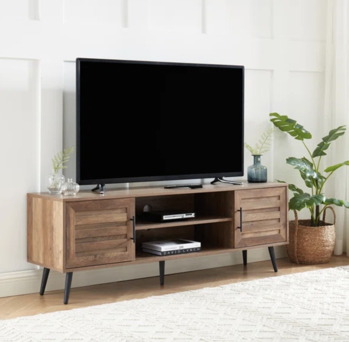 The brown stand has two open drawers and two spots with storage with doors