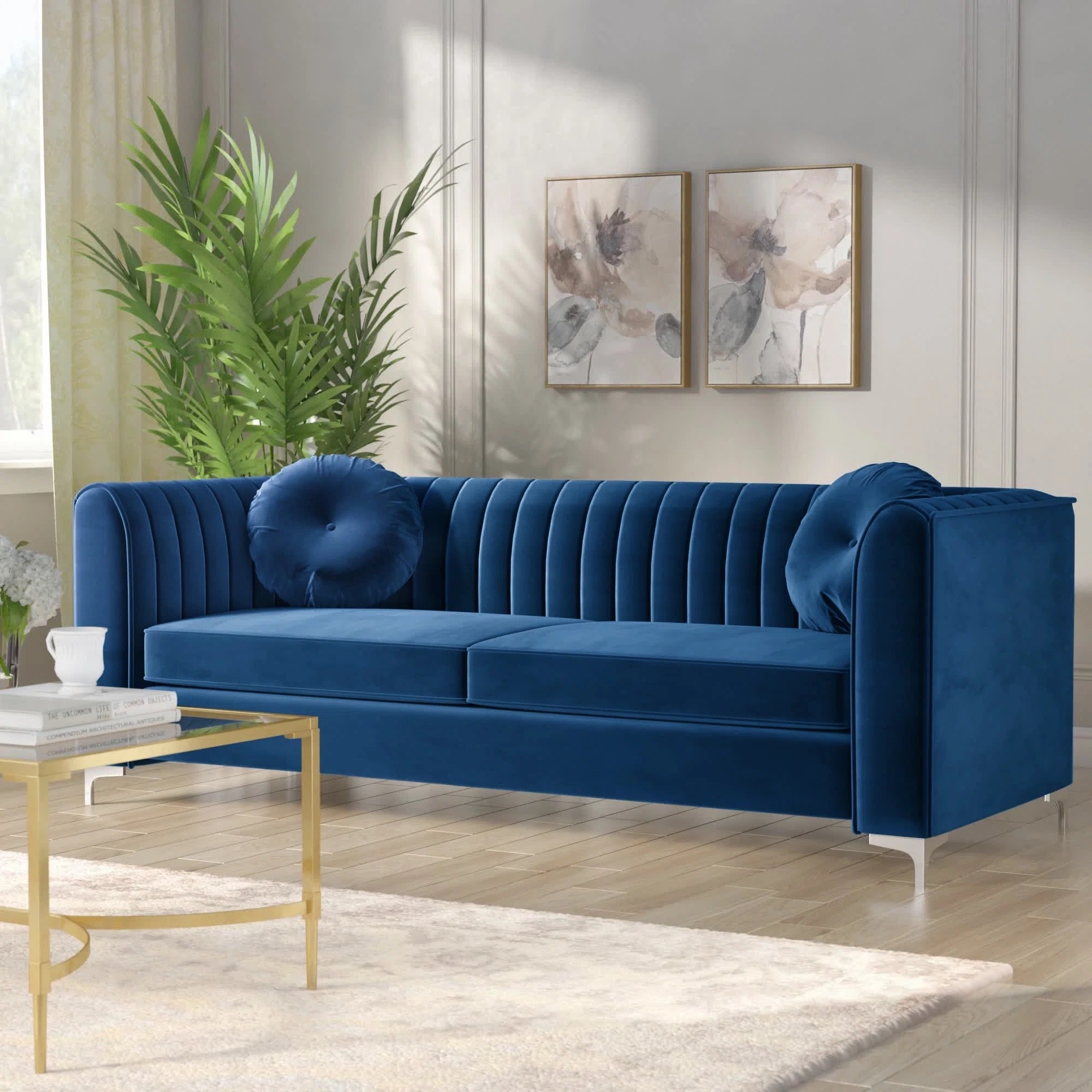 a navy colored velvet sofa with metalic legs in a living room