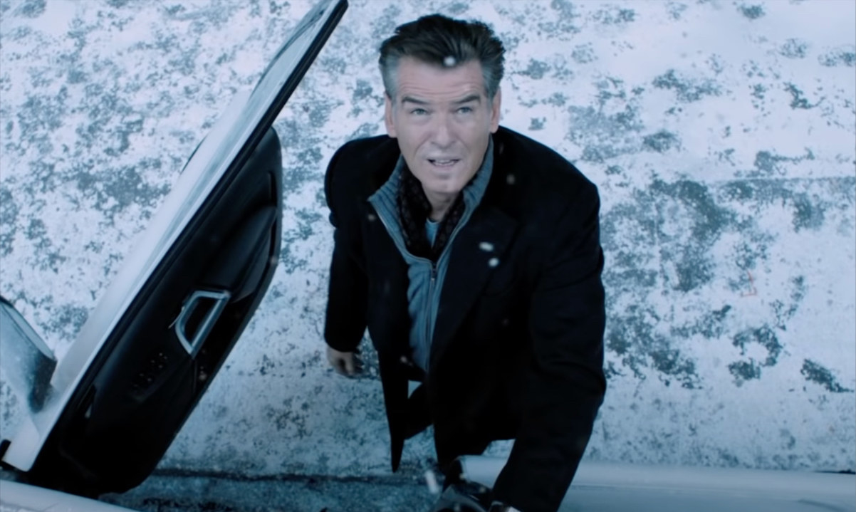 Pierce Brosnan standing in snow and looking up