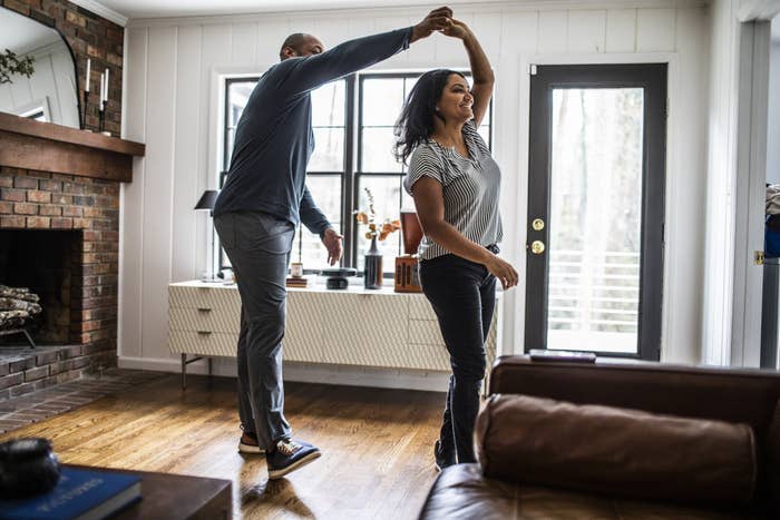 A man and woman dancing in their living room