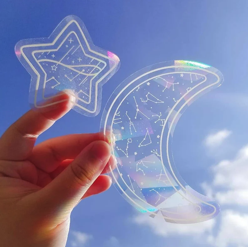 Hand holding star and moon sun catcher window decals