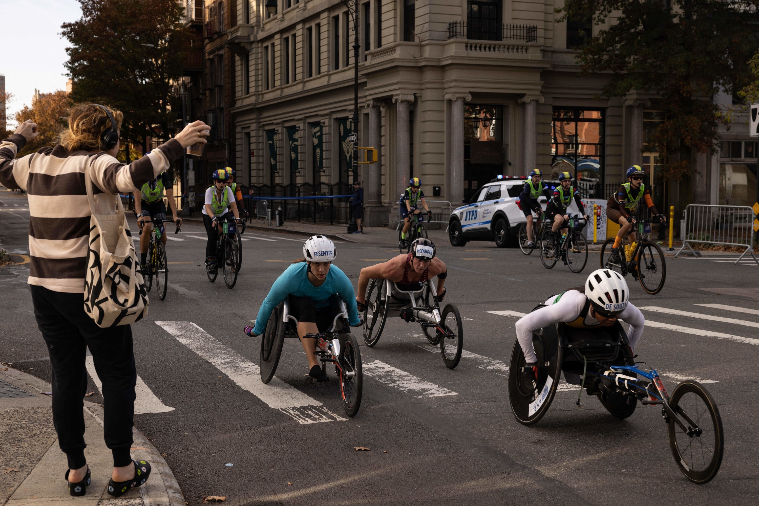 Three wheelchair racers and bicyclists