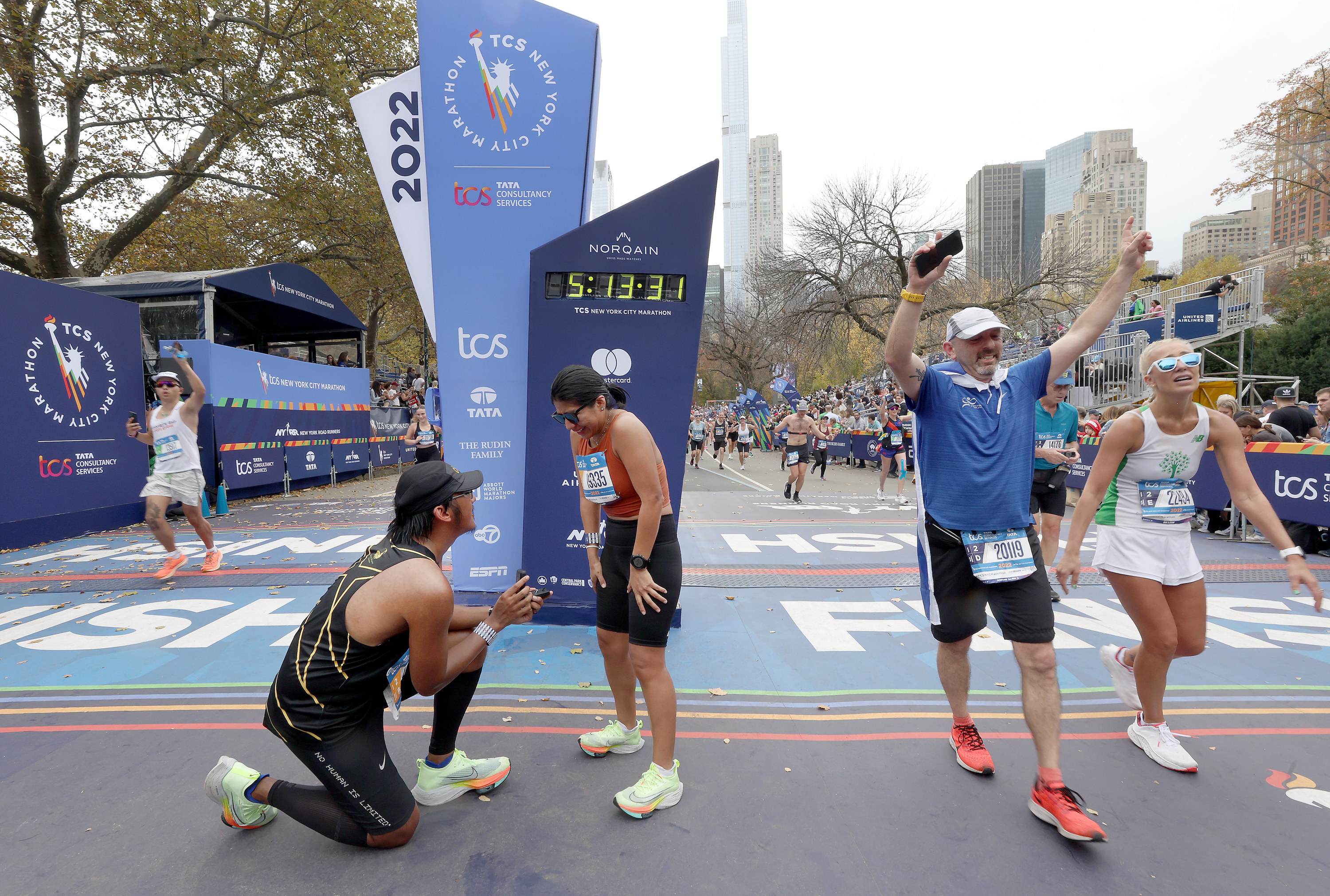 A man on bended knee at the finish line