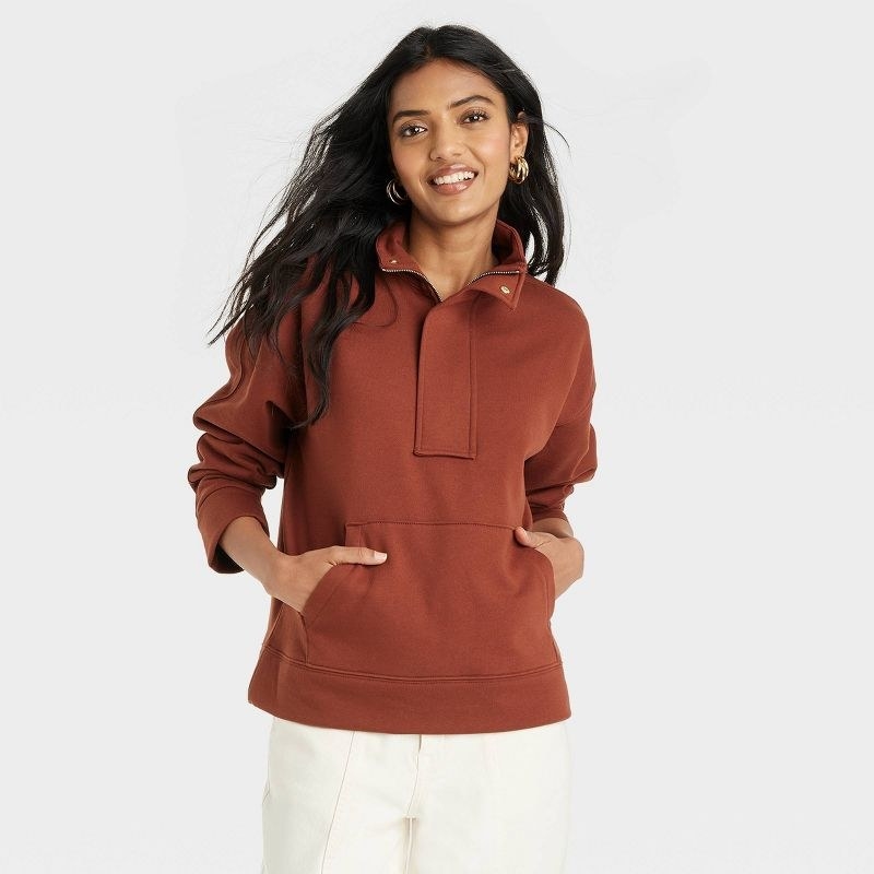 model wearing brown quarter zip sweatshirt