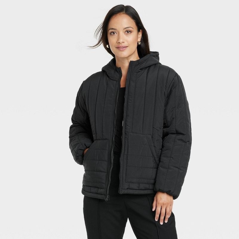 model wearing a black hooded puffer jacket