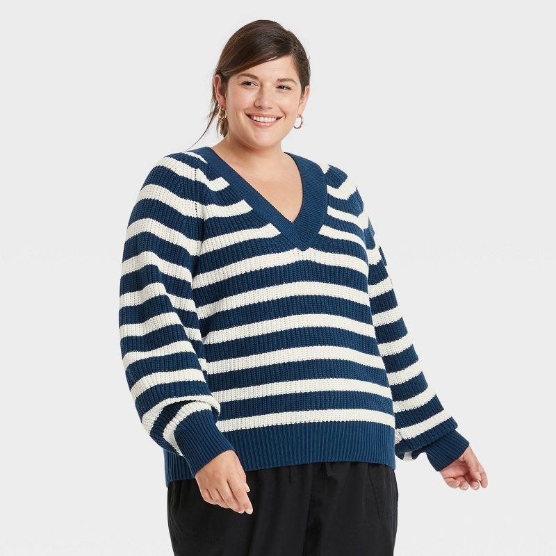 model wearing blue and white striped v-neck sweater