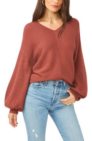 model wearing a red balloon sleeve sweater with jeans