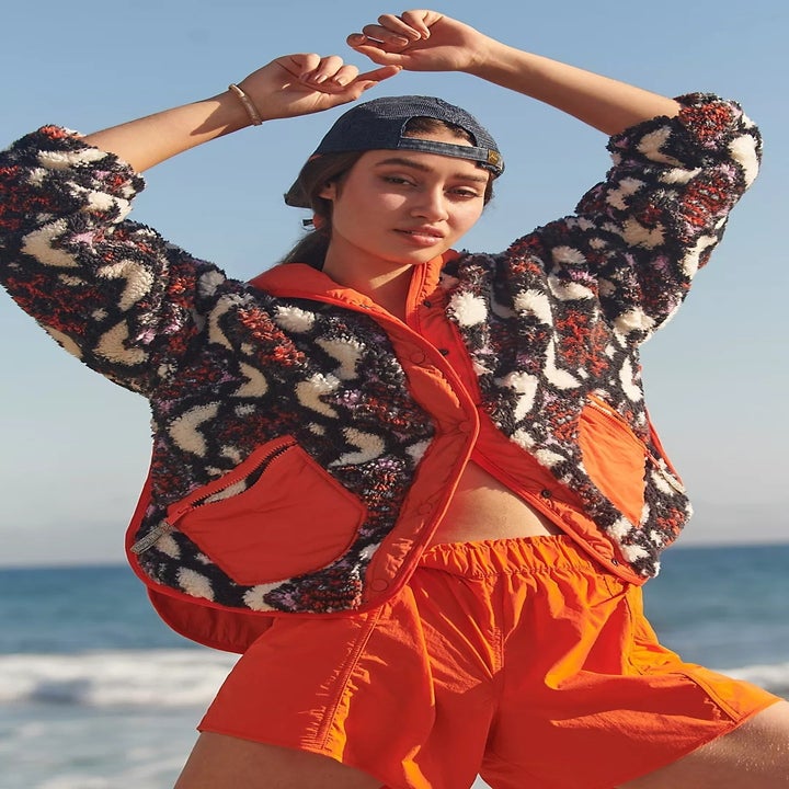 model wearing a multicolored fleece jacket with orange shorts