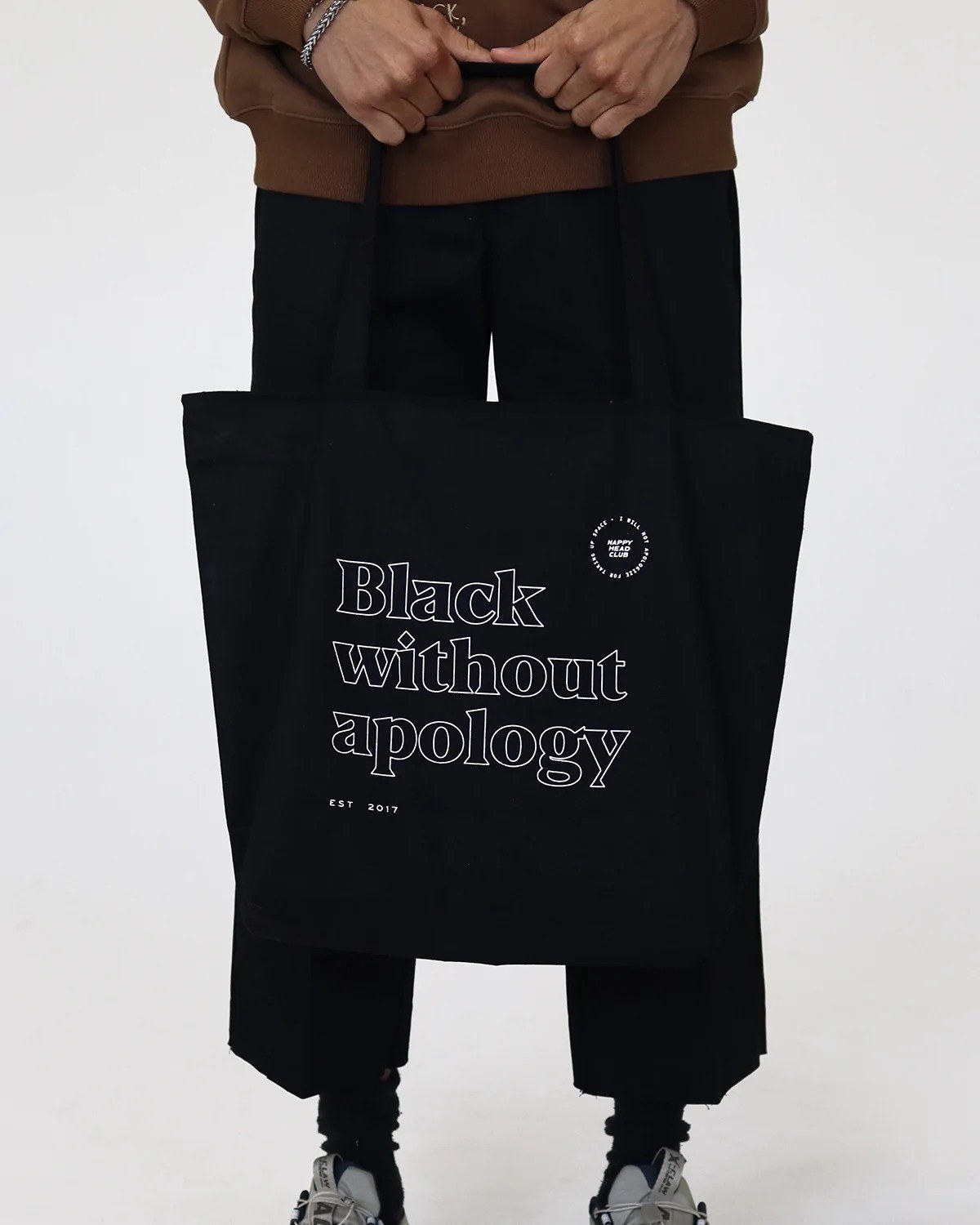 model holding black and white message tote