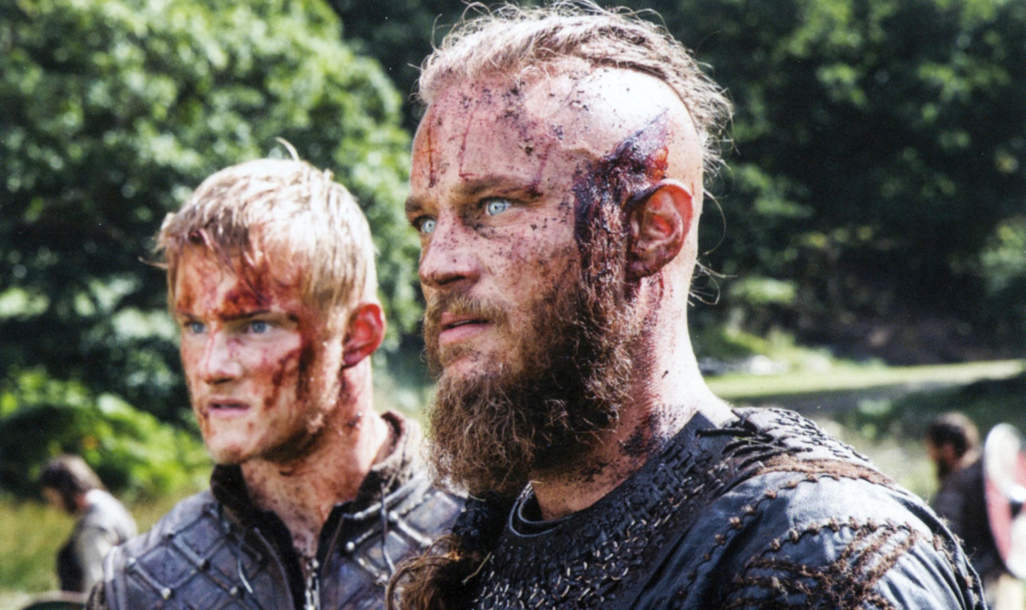Two young vikings soaked in blood stare incredulously at an unfolding dilemma