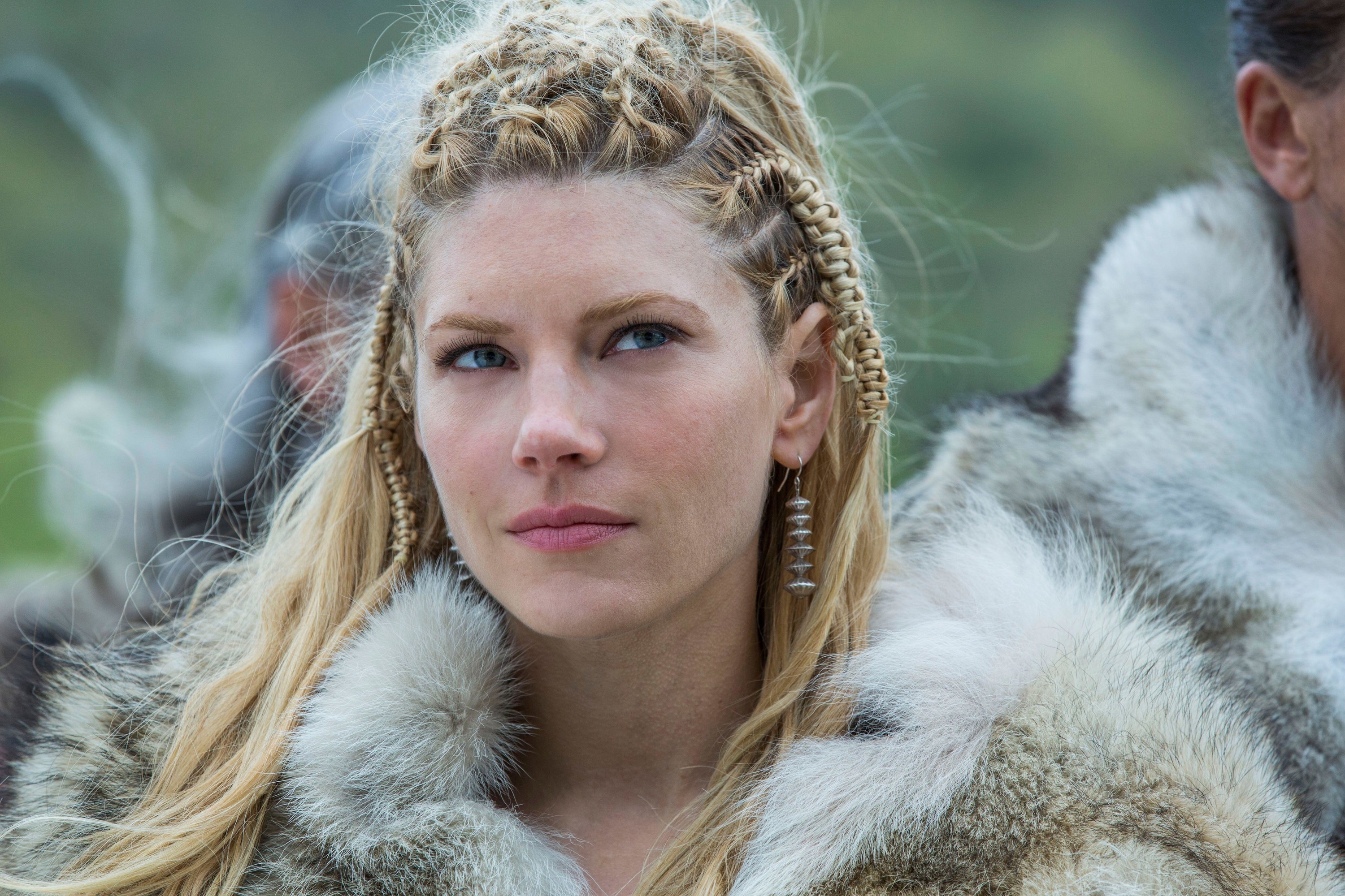 A viking woman offers a wry smile while observing a situation