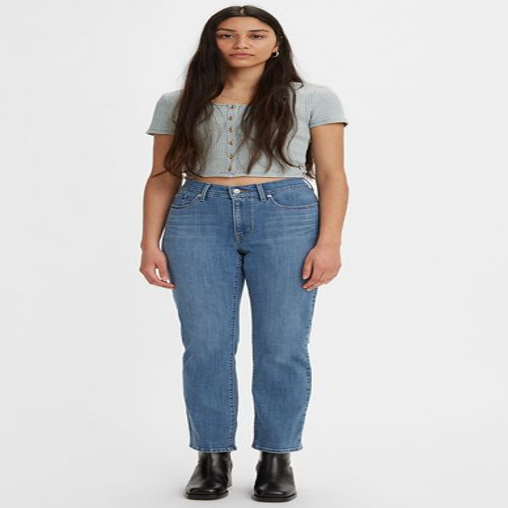 model wearing straight cut jeans in a medium wash with a light blue crop top and black boots
