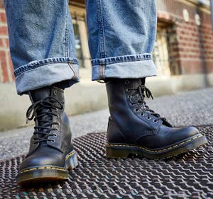 model wearing black lace-up Dr. Martens boots with cuffed jeans
