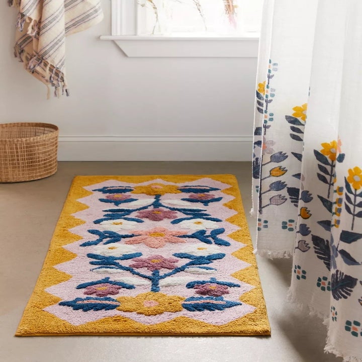 a multicolored floral bath runner on the floor of a bathroom