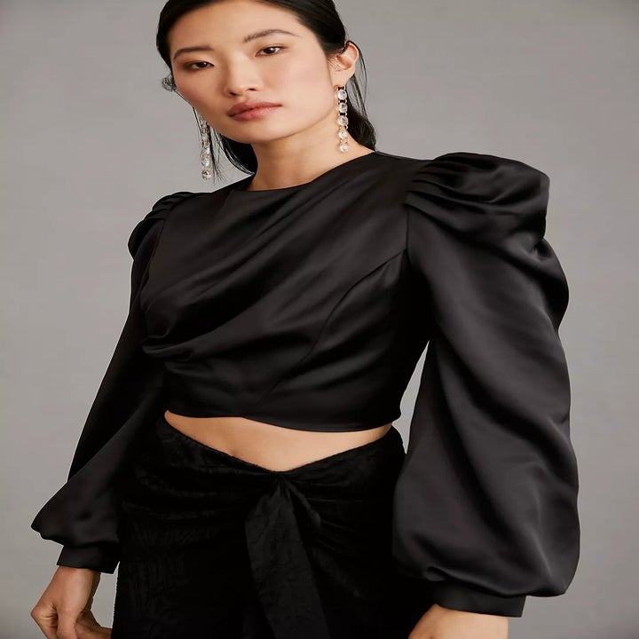 model wearing a black puff-sleeve top with black pants