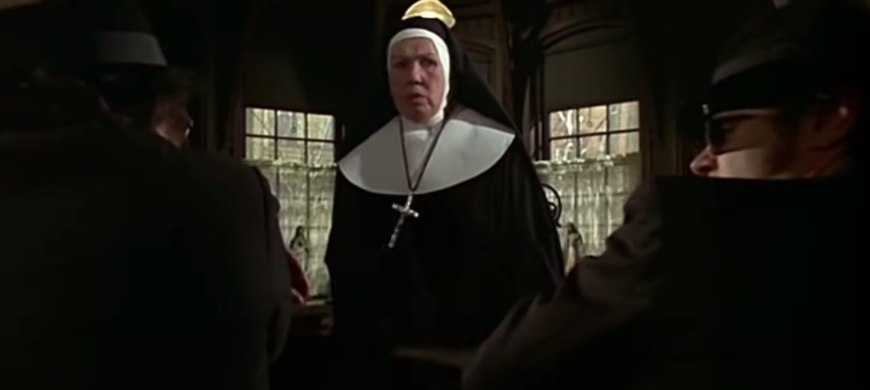 A nun whacks two men with a ruler