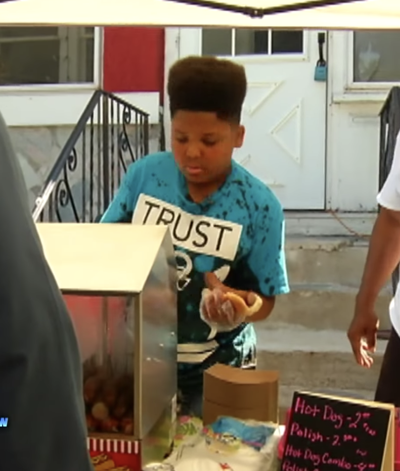 kid selling hot dogs