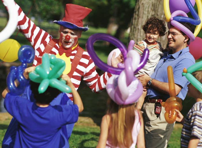 A clown makes balloon hats and balloon animals at a birthday party